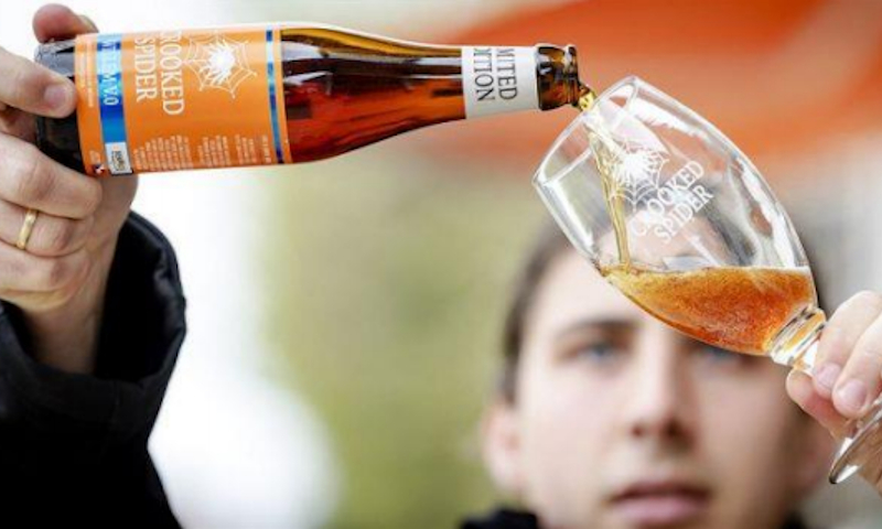 Brouwer Niels schenkt Crooked Spider bier in